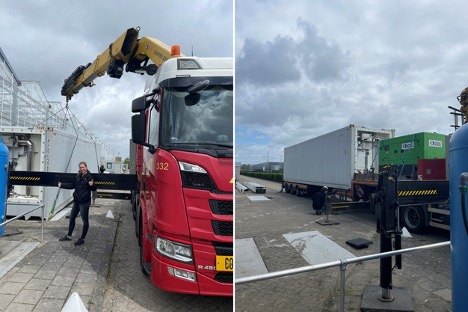 De container wordt met een kraanwagen bij de kas geplaatst