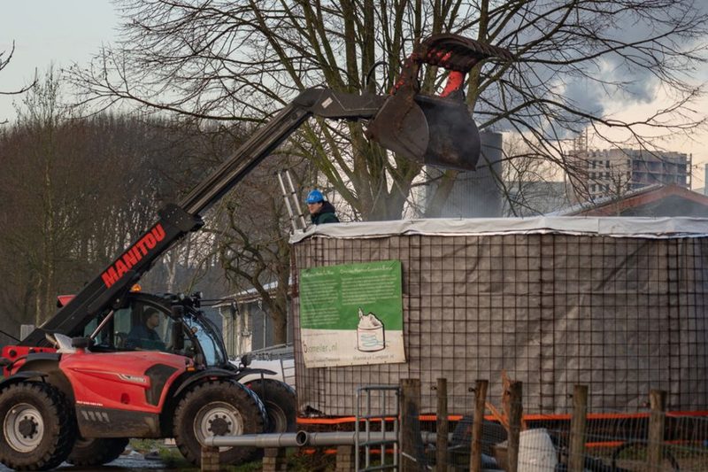 De biomeiler wordt gevuld met houtsnippers en mest