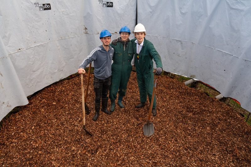 Studenten bij de biomeiler in aanbouw op De Tolakker